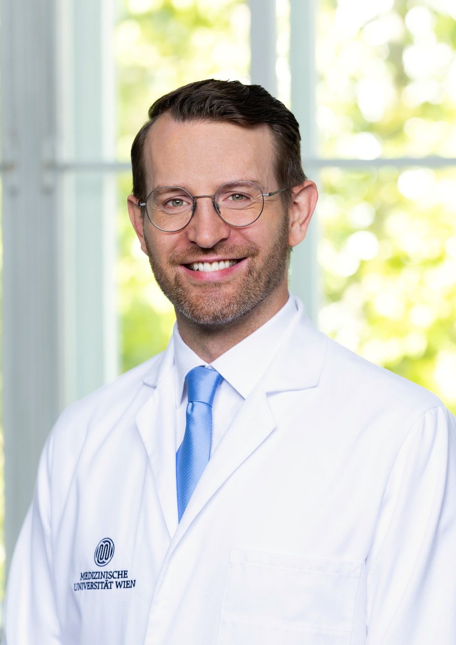 Dr. Julian Veser im Arztkittel der Medizinischen Universität Wien